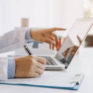 Scientist Using Laptop and Clipboard